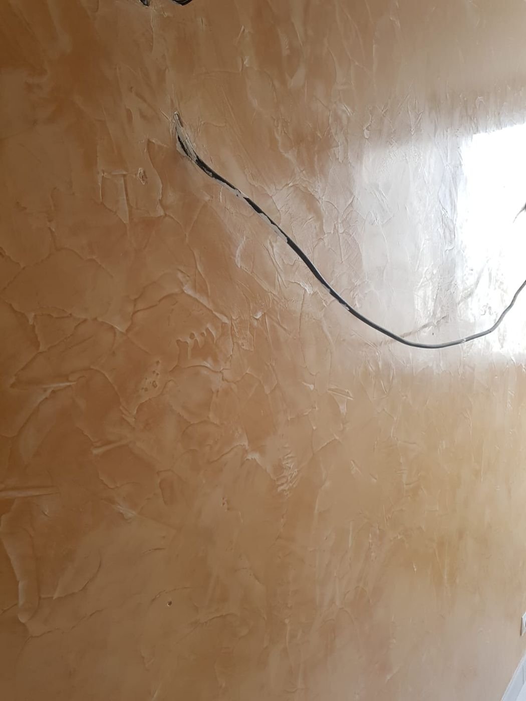 Finition d'enduit décoratif taloché sur un mur
