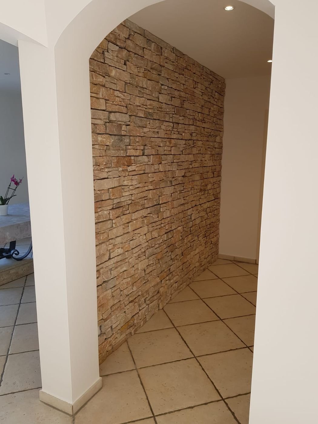Mur en pierre apparente dans une entrée voûtée