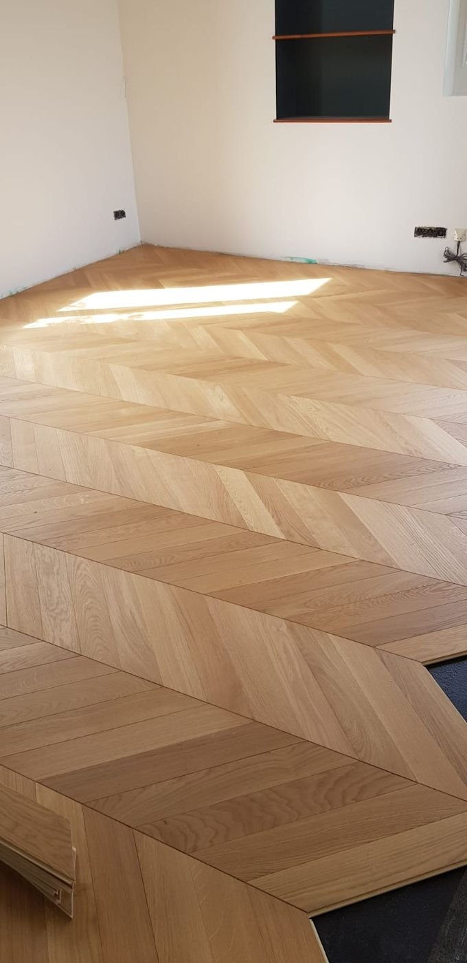 Parquet en chevron posé dans un salon baigné de lumière