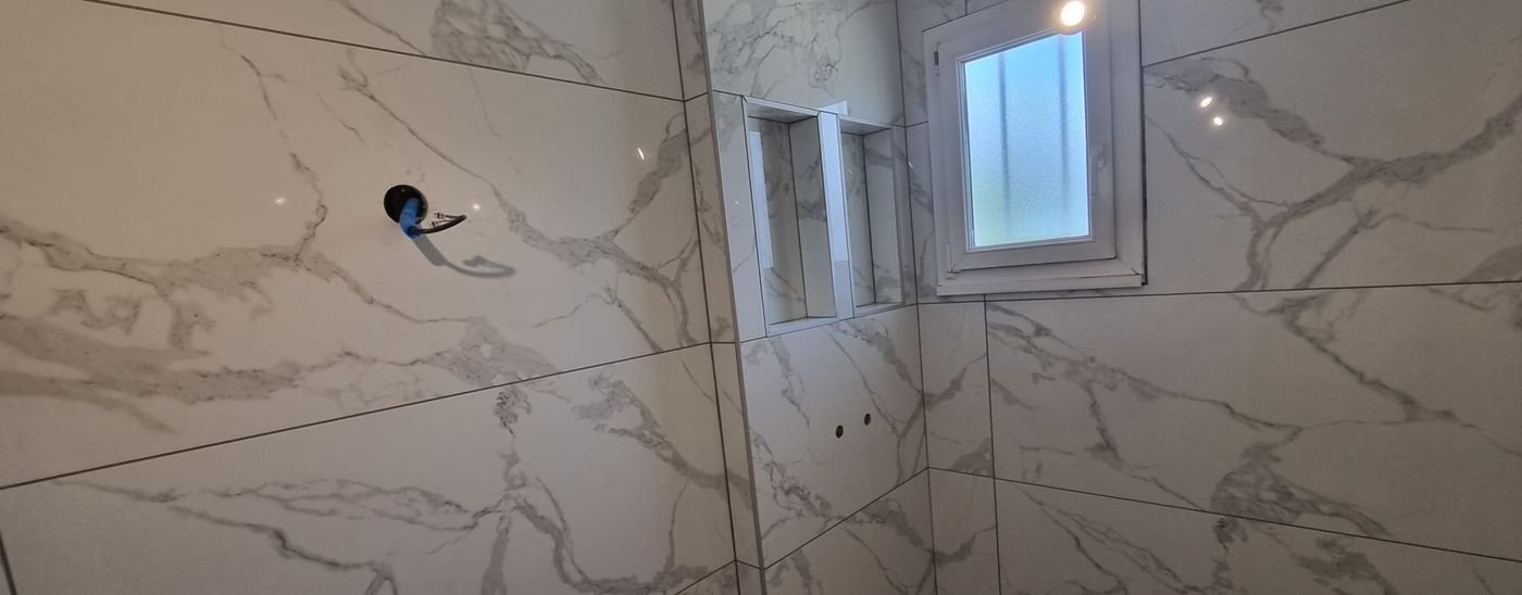 Salle de bain habillée de grand carrelage effet marbre
